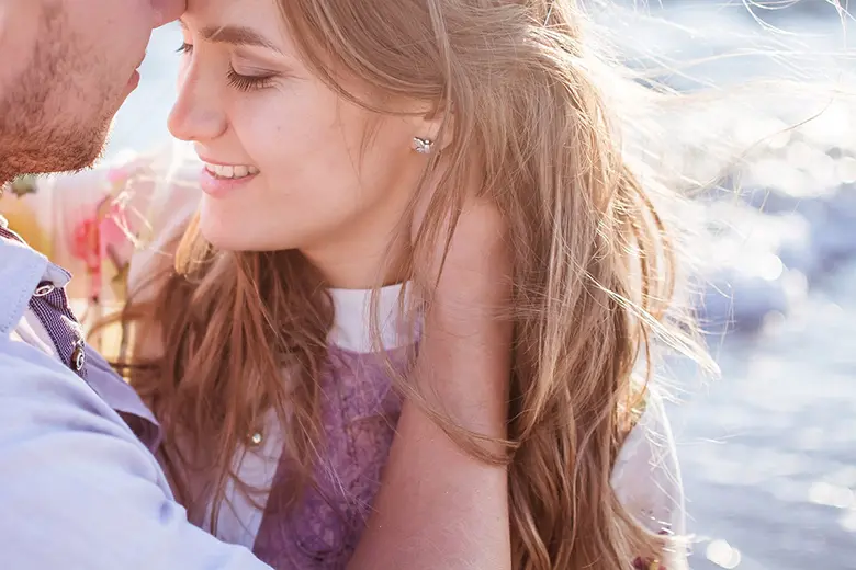 La imagen muestra a una mujer sonriente junto a su pareja