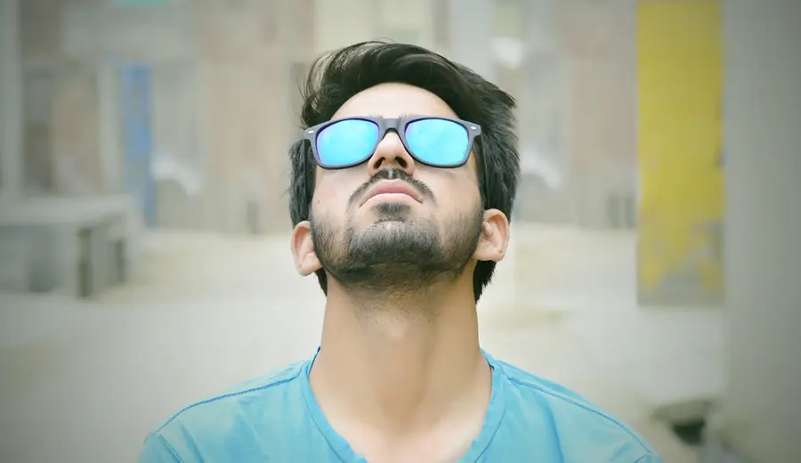 La imagen muestra a un hombre con lentes mirando al cielo